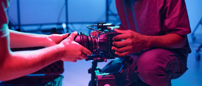 Young operator setting the camera with his assistant before shooting during his work in studio